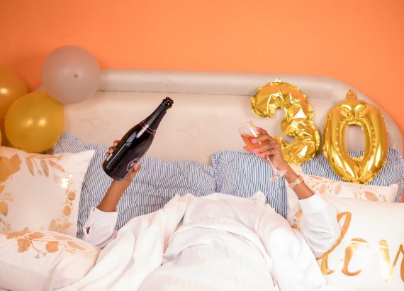 woman lying down in bed with champagne