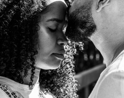 a man kissing a woman s forehead